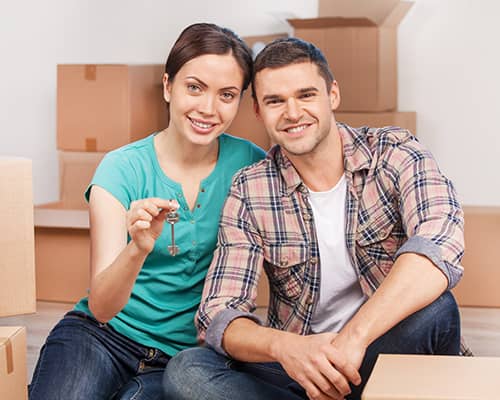 Cheerful young couple smiling while holding house key in Texas